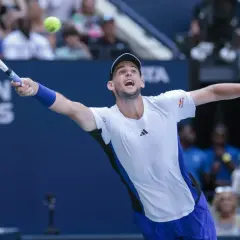 Dominic Thiem w akcji, uderza piłkę rakietą na korcie tenisowym.