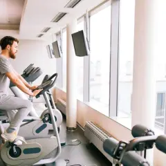 Mężczyzna ćwiczy na rowerze stacjonarnym, który może być dobrym wyborem, jeśli zastanawiasz się, jaki rower stacjonarny do rehabilitacji kolana wybrać.
