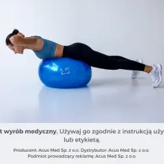 Kobieta wykonuje ćwiczenie na dużej, niebieskiej piłce do ćwiczeń. Rozmiar piłki jest odpowiedni do jej wzrostu.