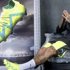 Neymar w neonowych butach piłkarskich Puma, idealnych na sztuczną trawę, siedzi na tronie.