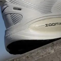 Biały but sportowy z technologią ZoomX. Drop w butach to różnica wysokości między piętą a palcami, kluczowa dla komfortu biegu.