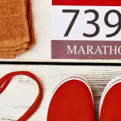 Pomarańczowy ręcznik, czerwone buty i numer startowy 7395 z napisem MARATON. Czas na maraton!