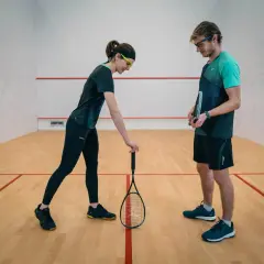 Para, która omawia zasady squash serwisu na korcie.