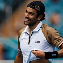 Uśmiechnięty Matteo Berrettini w czapce z daszkiem i koszulce z logo BOSS.