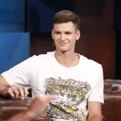 Uśmiechnięty Hubert Hurkacz, zapytany ile ma lat, siedzi na kanapie w studiu.