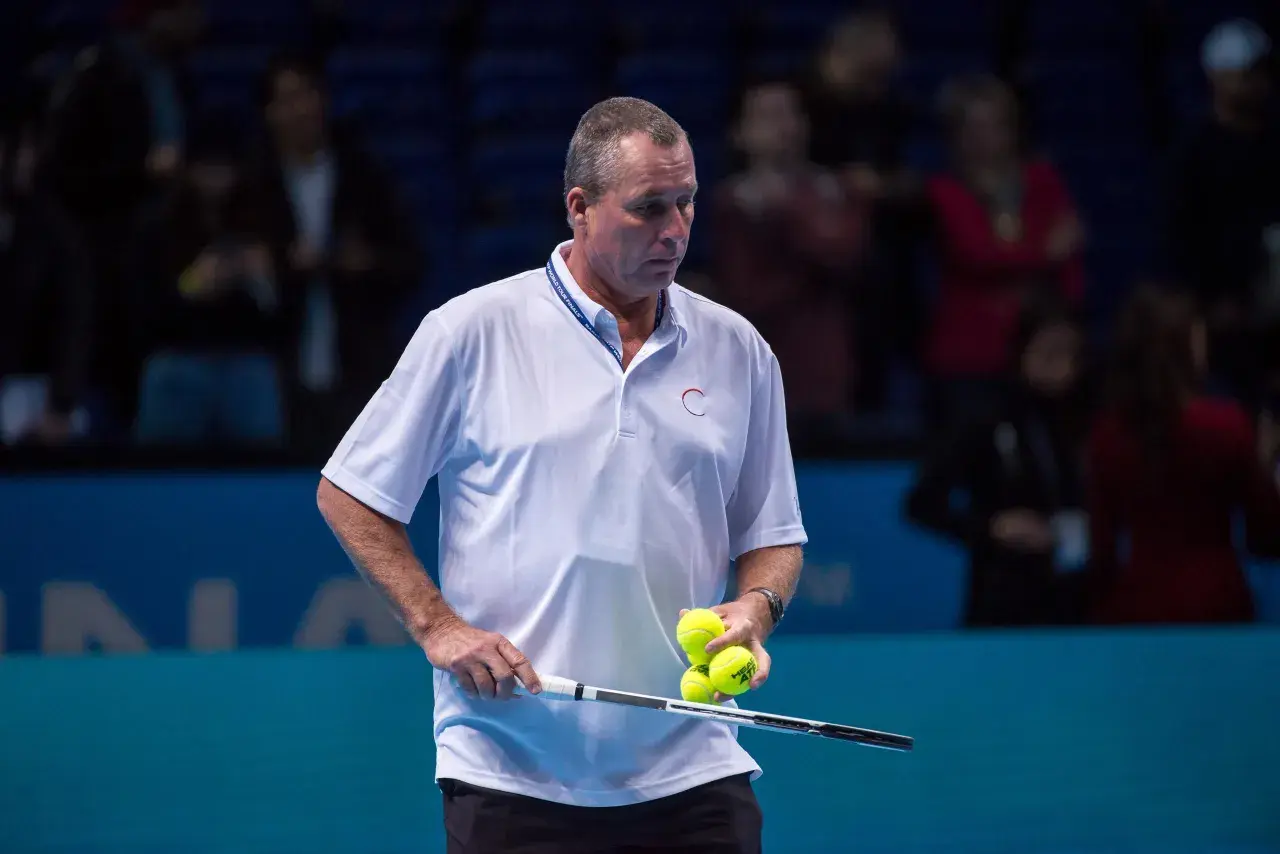 Ivan Lendl, były tenisista, trzyma rakietę i piłki tenisowe na korcie.