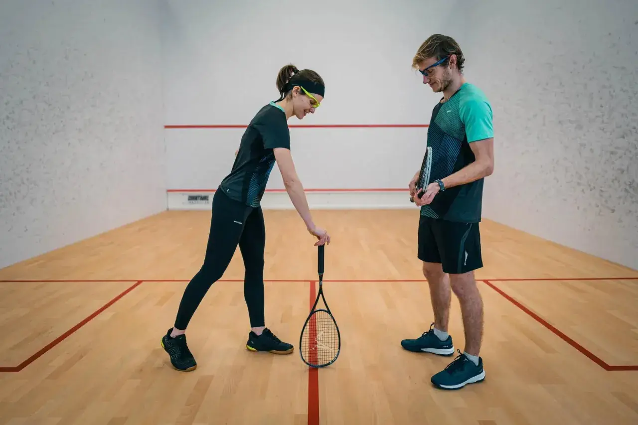 Para, która omawia zasady squash serwisu na korcie.