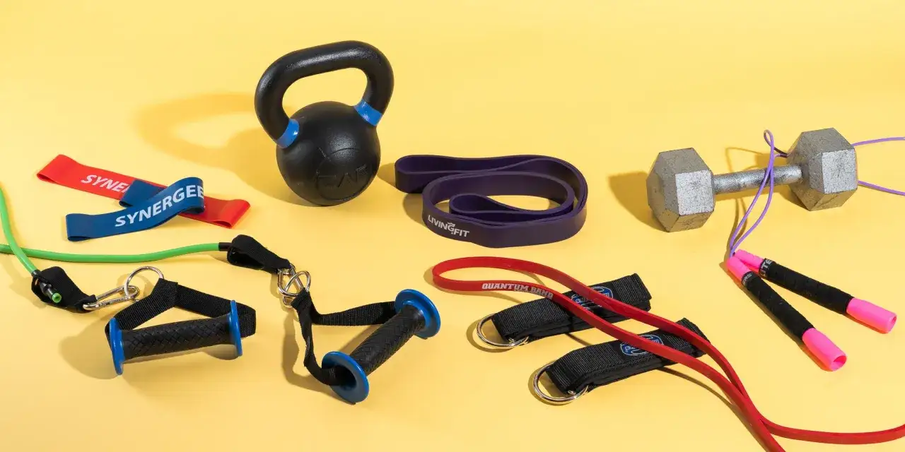 Zestaw do ćwiczeń: kettlebell, hantle, skakanka i różne gumy do ćwiczeń, w tym taśmy oporowe i pętle.