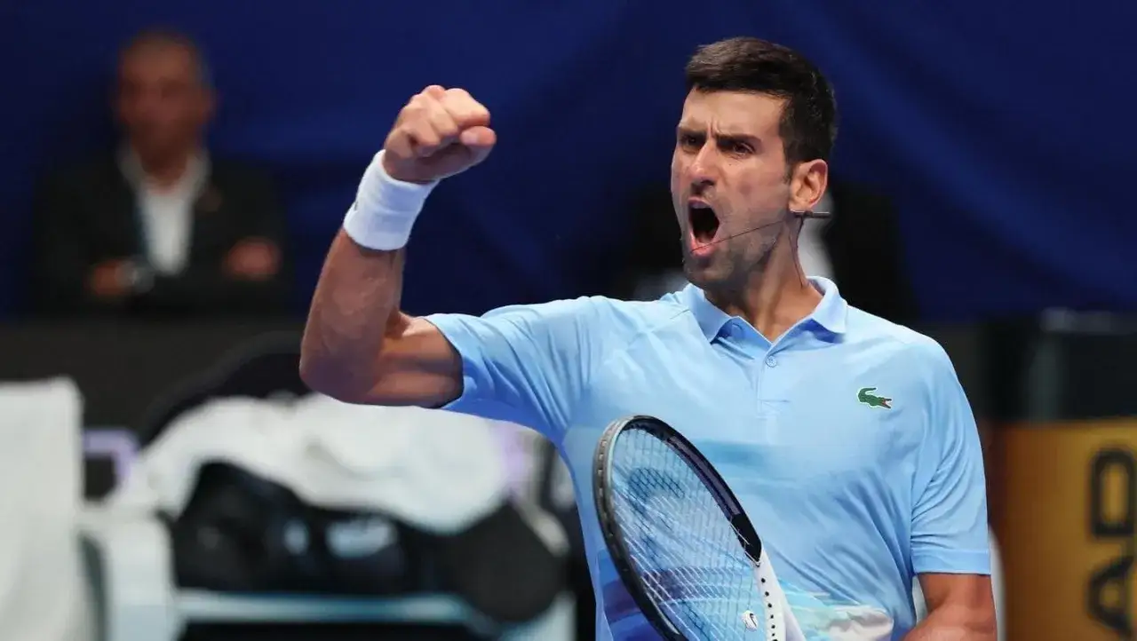Novak Djokovic, którego wzrost jest imponujący, świętuje zwycięstwo na korcie.