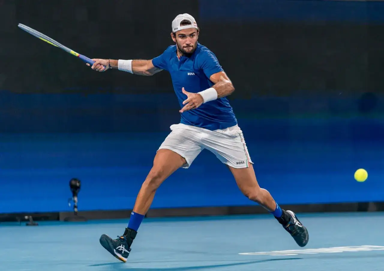 Matteo Berrettini w akcji, uderza piłkę rakietą podczas meczu tenisowego.